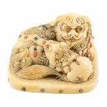 Ivory netsuke. Japan. 19th century.Depicts a shishi resting on the ground, licking her son. The body