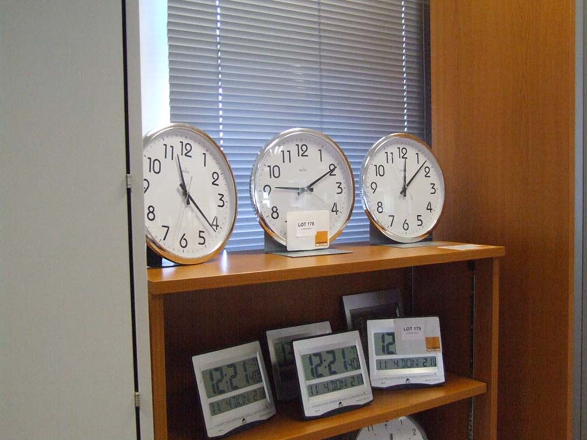 3 Analogue battery clocks on top shelf