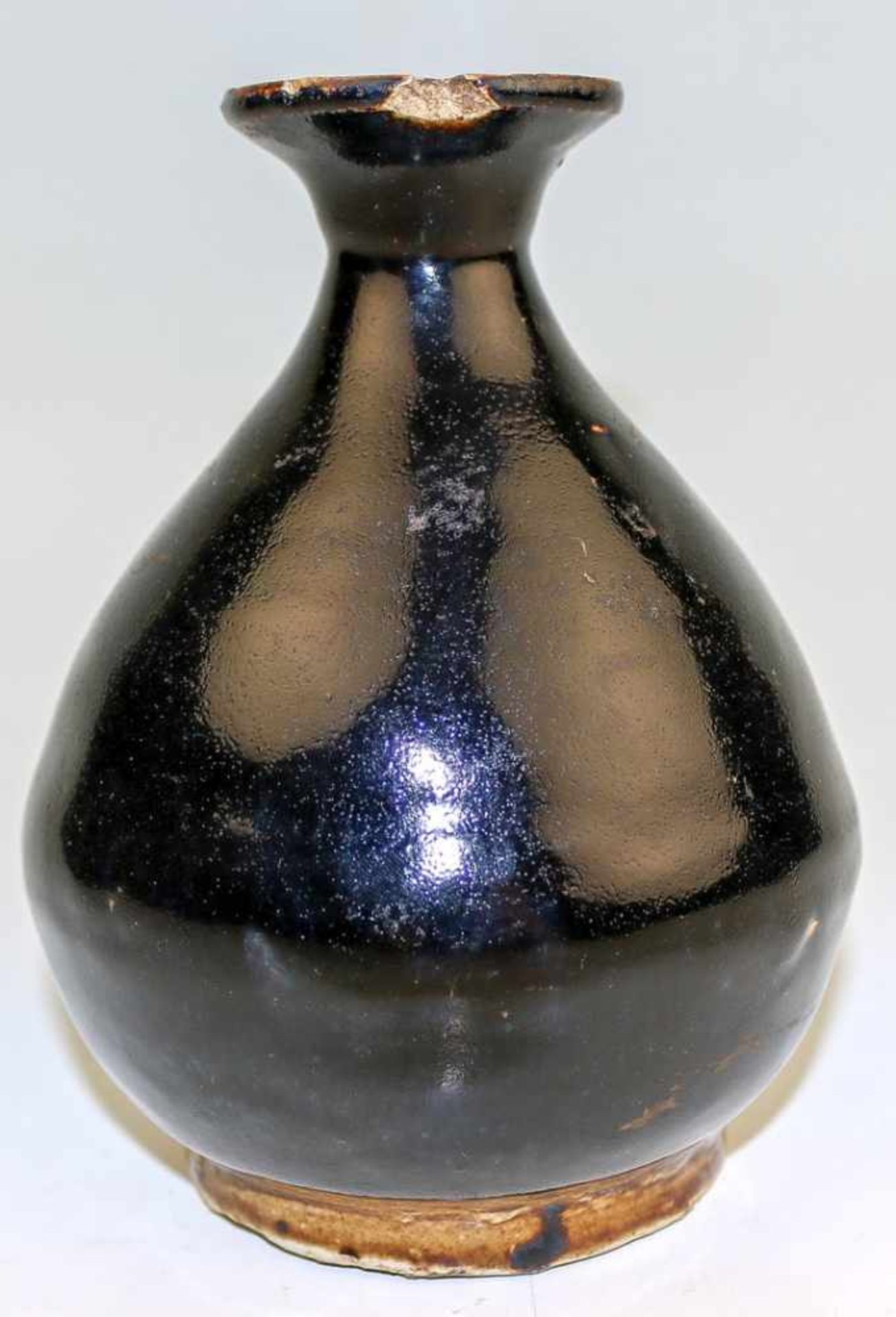 Bauchige VaseChina, wohl Yuan/Song-ZeitHelles Steinzeug, schwarz glasiert. H. 16 cm. (Mündung best.,