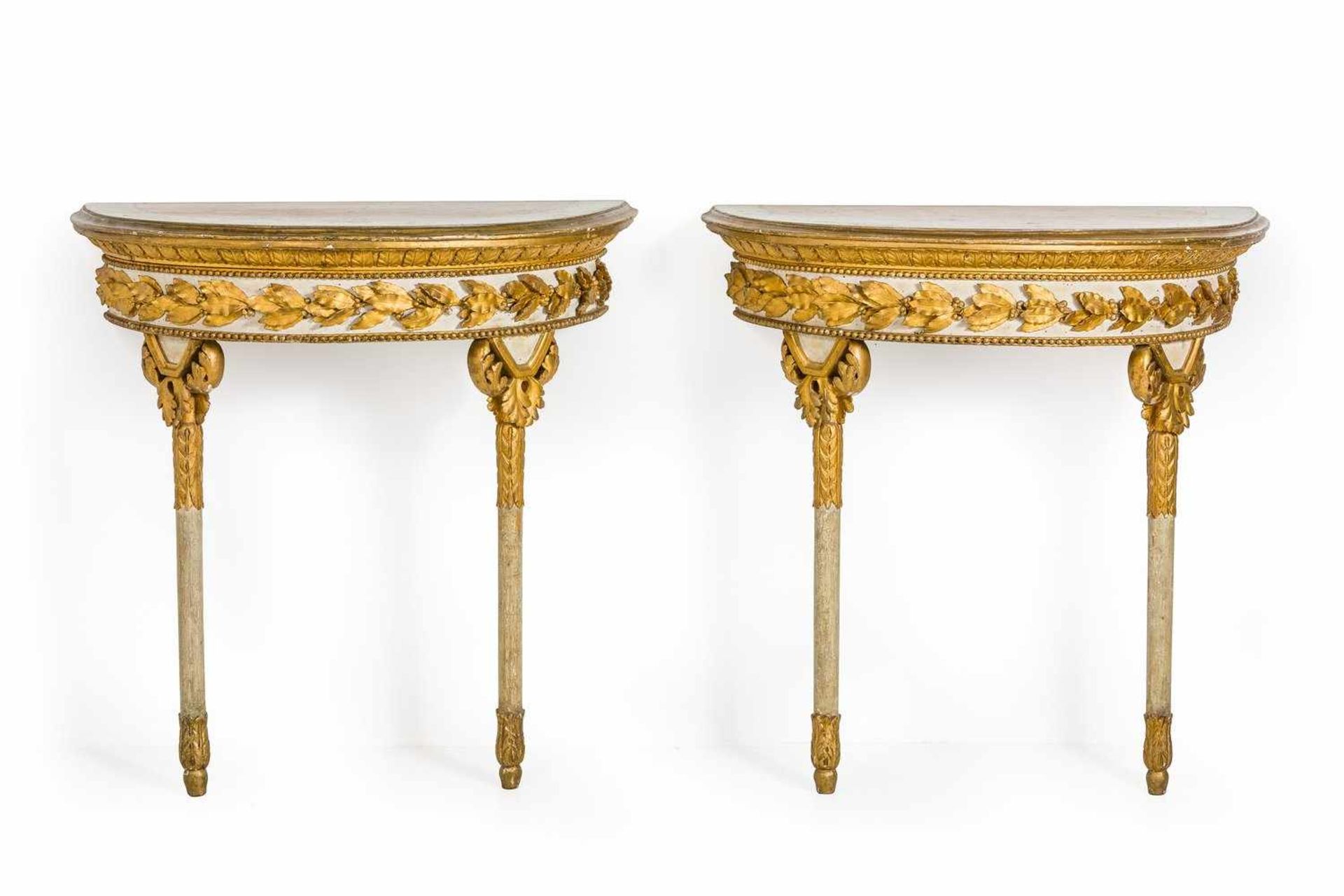 Ein Paar Louis-XVI-KonsoltischeWohl Italien, 18. Jh.Holz, weiß gefasst und vergoldet. Demilune-Form.