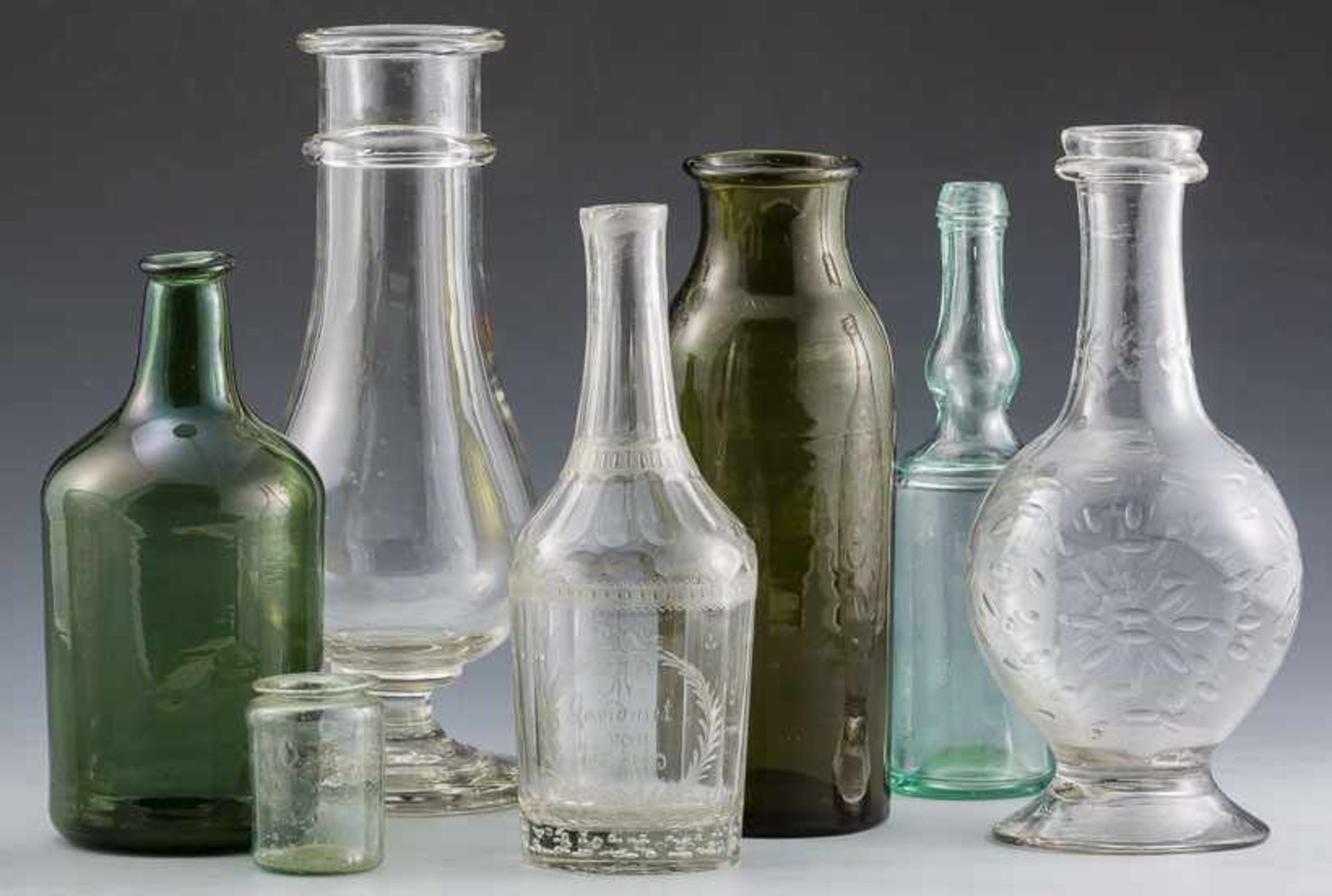 ZylinderflascheDeutsch, 19. Jh.Grünes Glas. Boden leicht hochgestochen. H. 20 cm. Dazu: