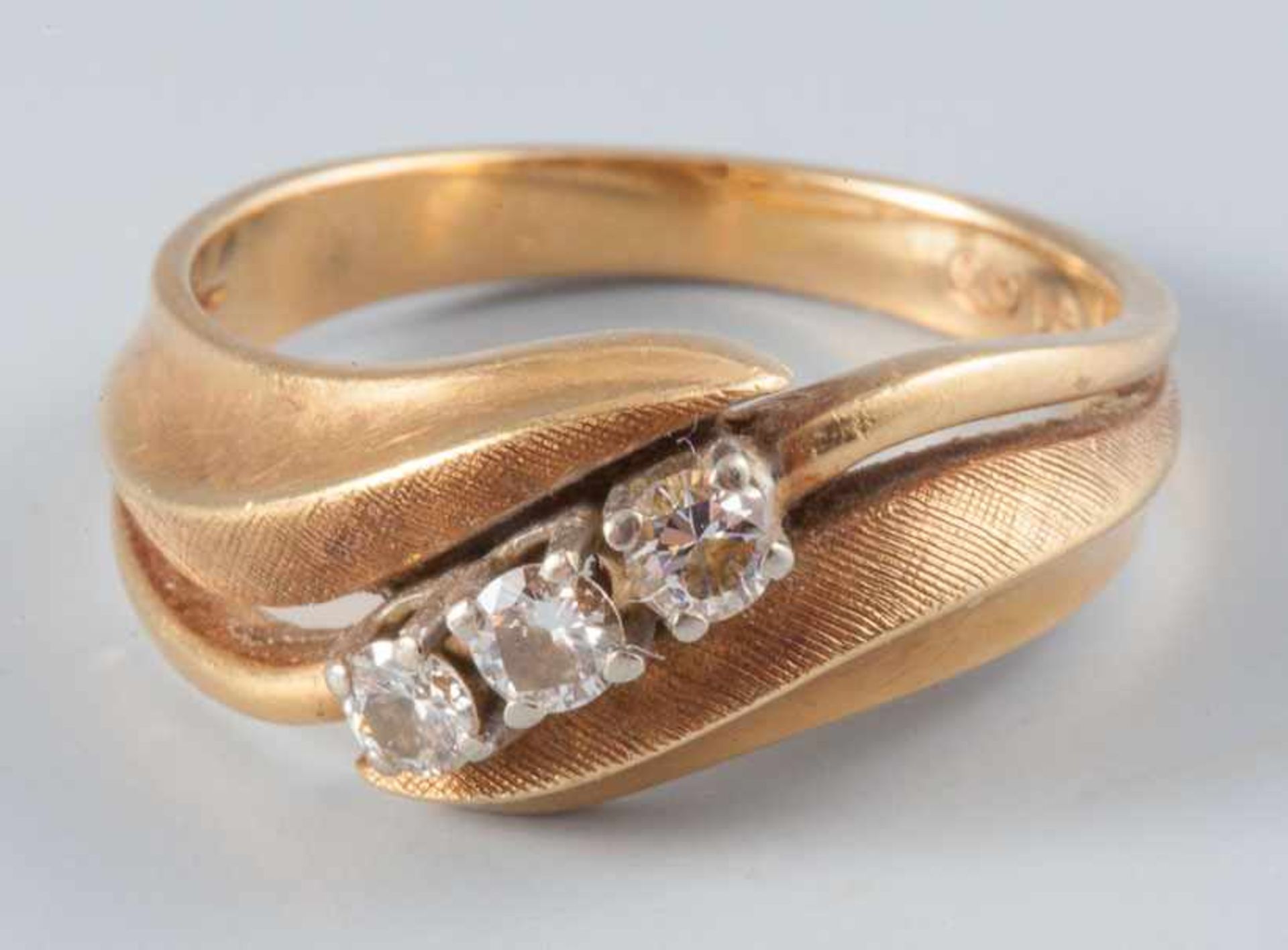 Goldring750/f. Gold. Ausgefasst mit 3 kl. Brillanten von zus. ca. 0,30 ct. Fa. G. Lauer,