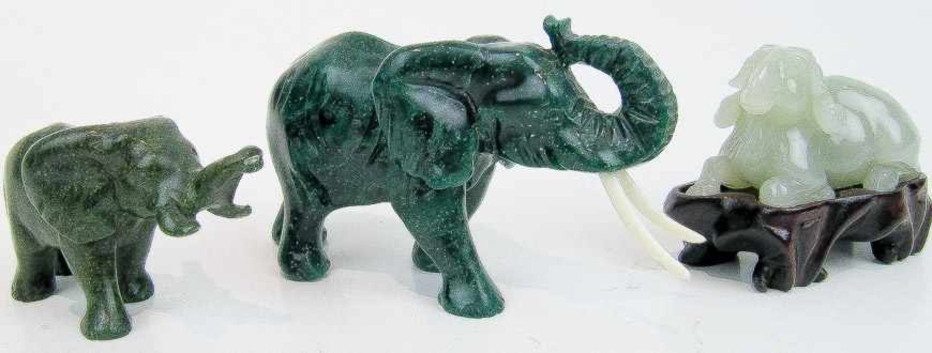 Liegender WidderHellgrüne Jade. L. 6,5 cm. Holzsockel. Dazu: Zwei Elefanten. a) Malachit m. Bein-