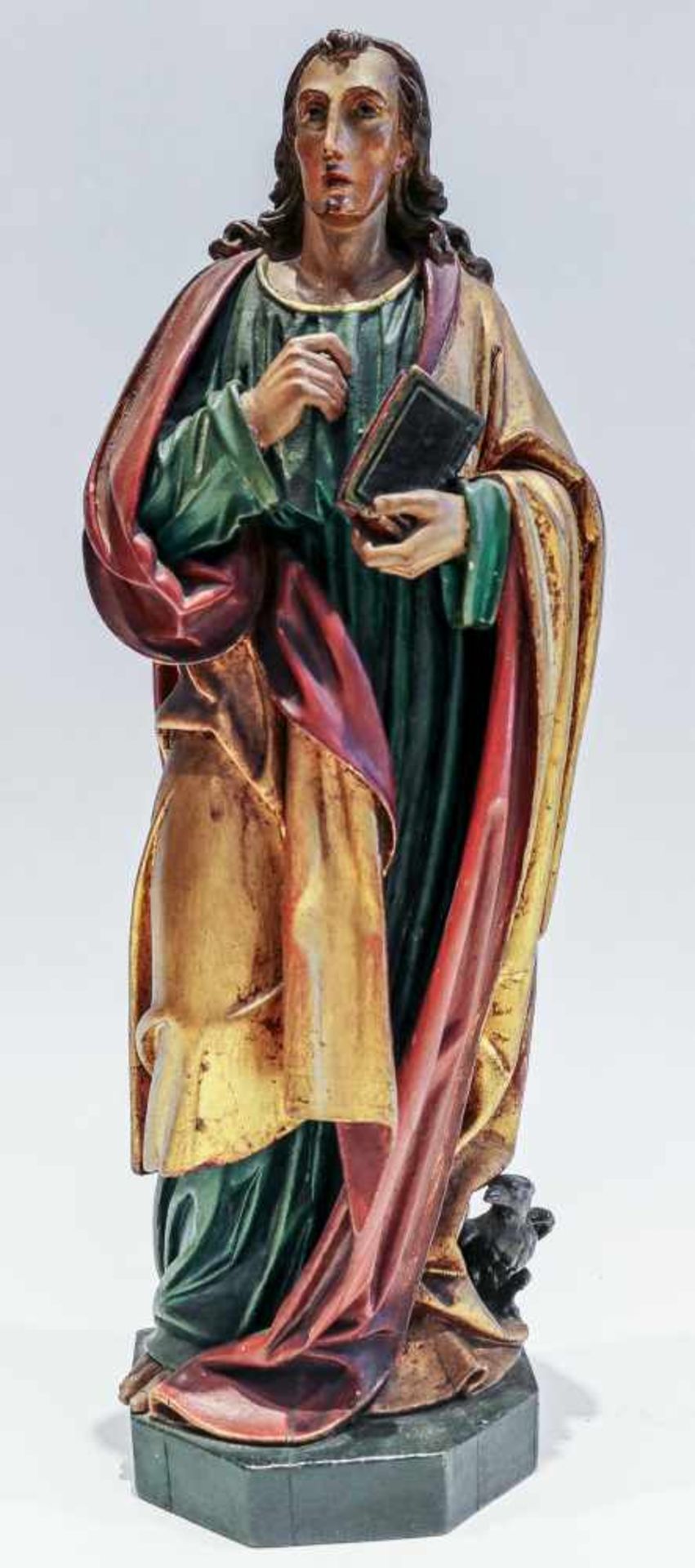 Apostel Johannesmit Evangelium und Adler zu Füßen. Holz geschnitzt und farblich gefasst. H. 47 cm.