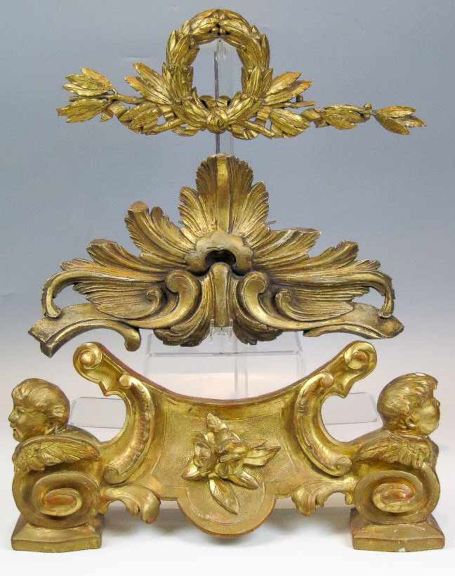 Drei Schnitzereien18./19. Jh.Holz, vergoldet. a) Schleifenbekrönung aus Lorbeerblättern. B. 49 cm.