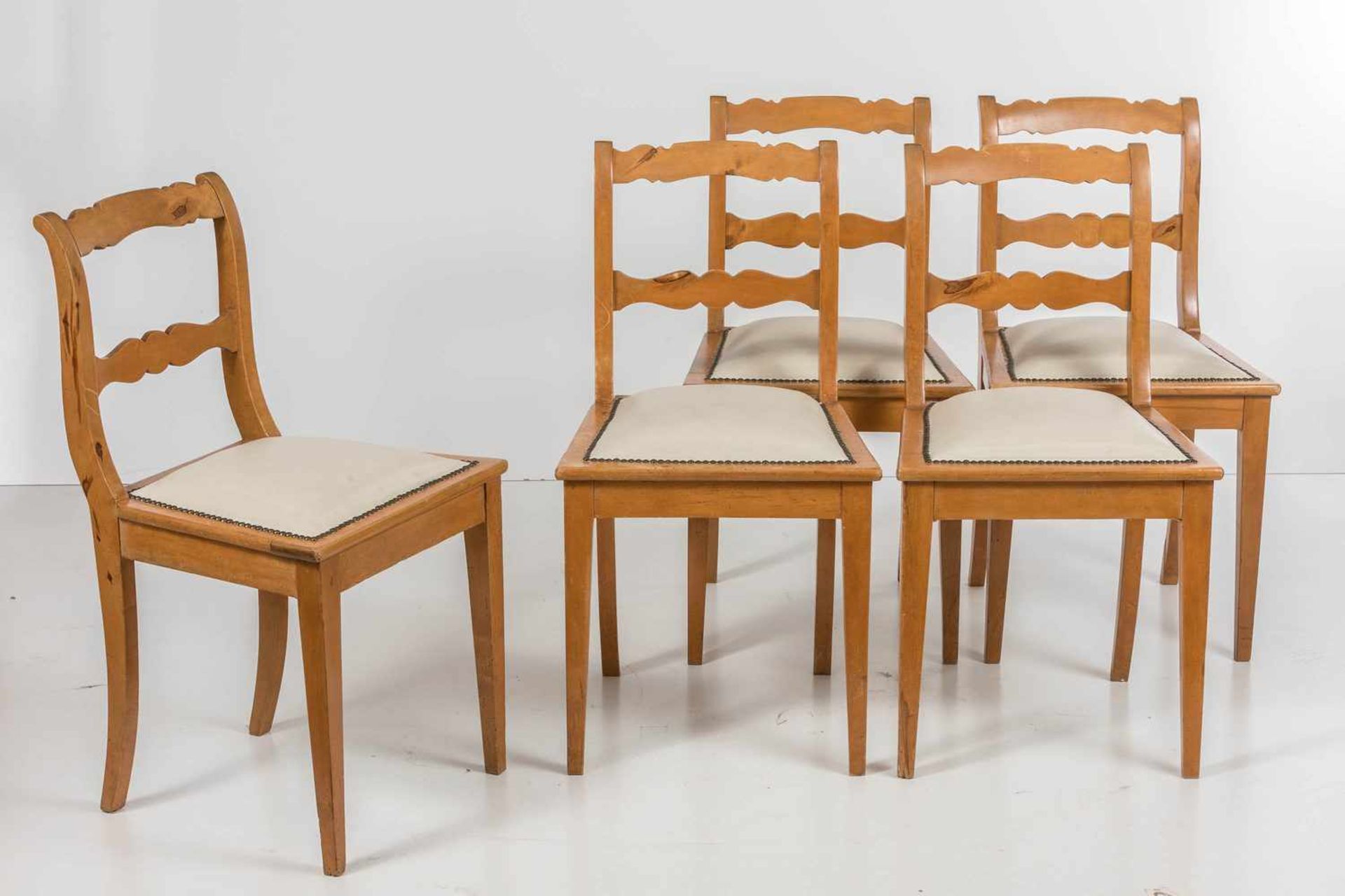 Fünf Stühle im BiedermeierstilObstholz. Trapezförmiger, breitrahmiger, gepolsterter Sitz mit