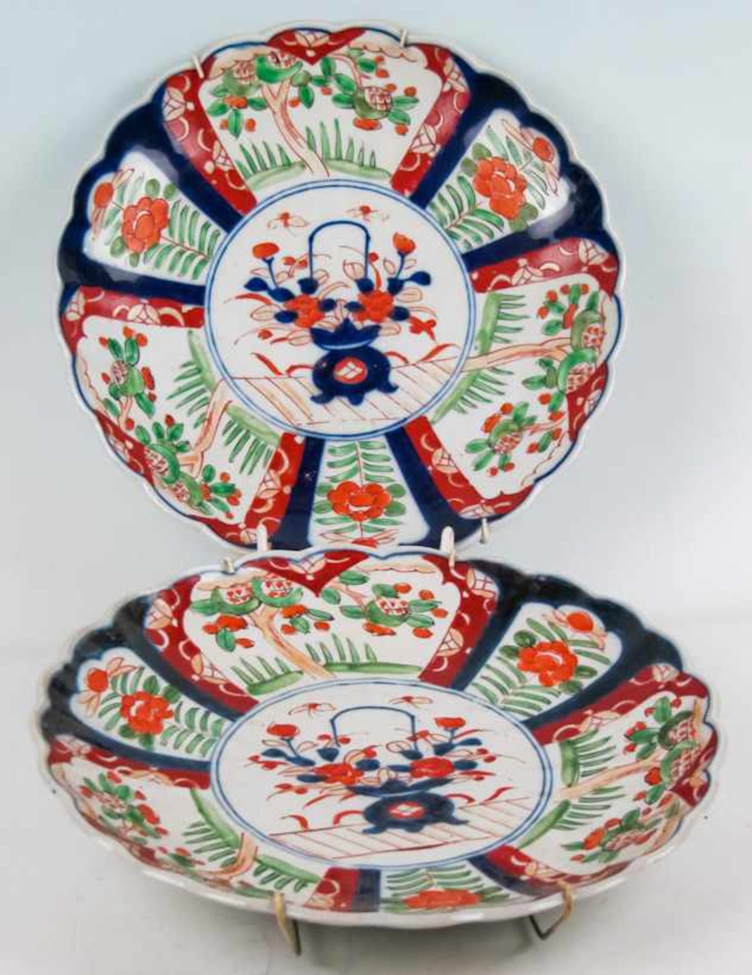 Ein Paar Platten mit blütenförmigem RandJapan, ImariPorzellan. Landschaften und Blumen um