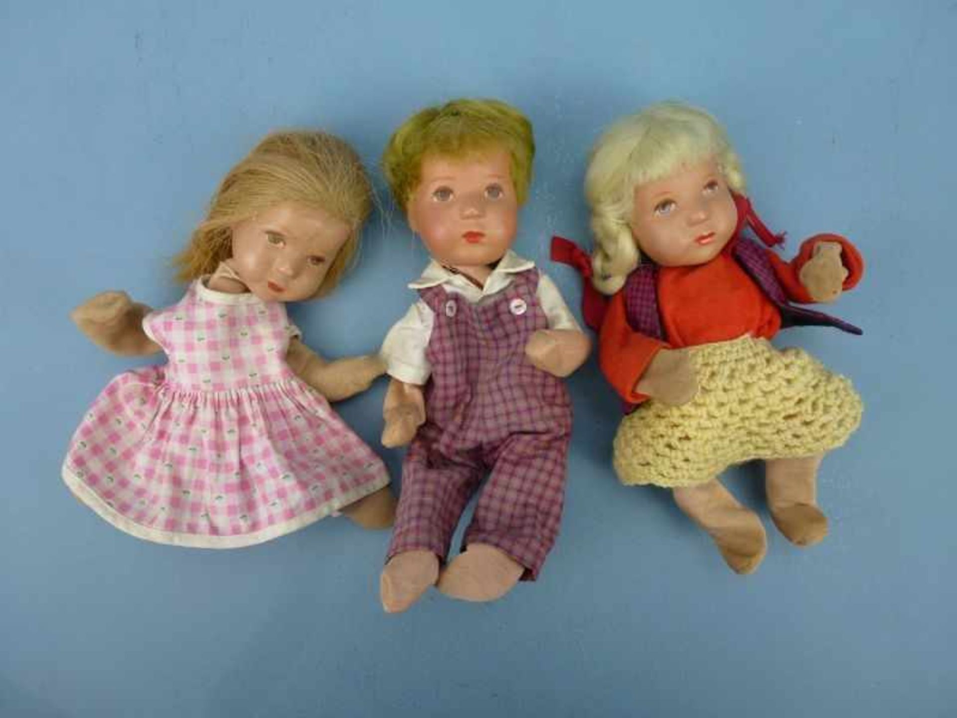 3 Käthe Kruse-Puppen, 1960er/70er Jahre bemalter Kunststoffkopf, Füllmaterial des Körperszersetzt, L