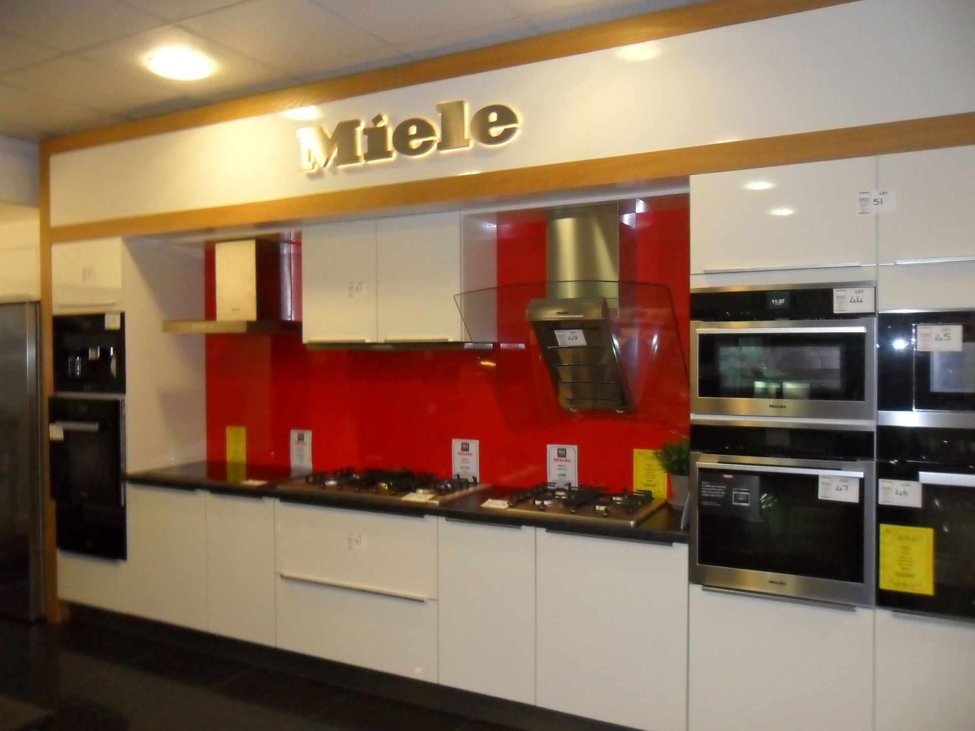 Miele cream FITTED KITCHEN with deep red splash back feature wall