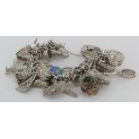 Silver / white metal charm bracelet with a good quantity of charms attached. Approx 108g