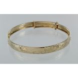 9ct machine engraved adjustable bangle, weight 7.7g