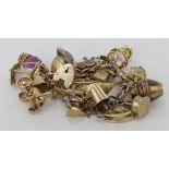 9ct / Yellow metal charm bracelet with a good selection of charms attached, approx 77.8g