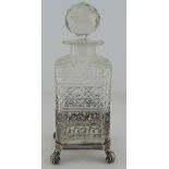 Cut glass decanter, in a silver plated stand, raised on four scroll feet, height 23.5cm approx.