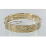 9ct yellow gold hinged machine engraved bangle with box clasp and safety chain, weight 19.9g