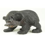 Carved wooden bear carrying a large fish, height 11cm, length 19cm approx.