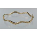 9ct yellow gold hollow hinged wavy bangle with box clasp and safety catch, weight 5.2g