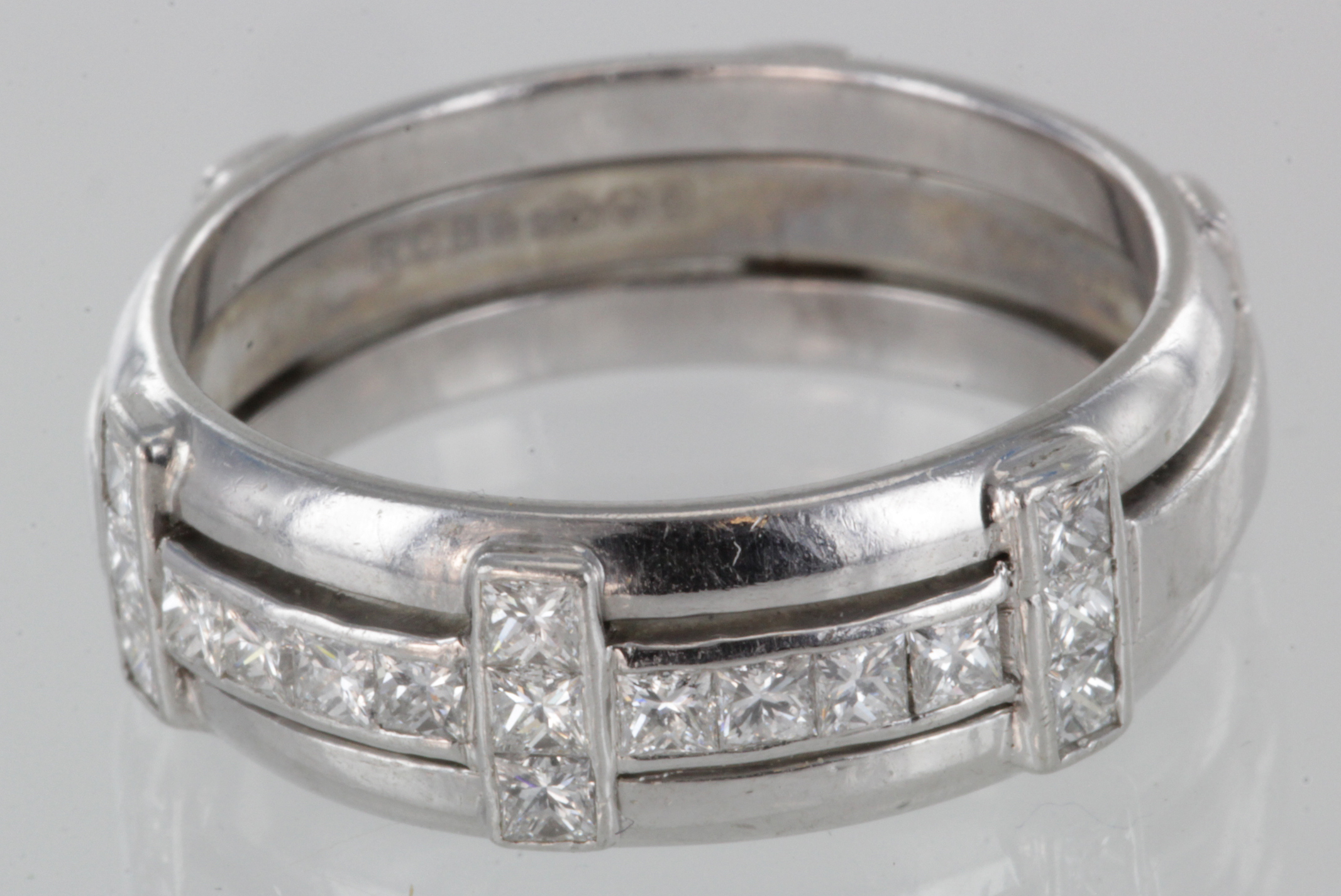 Ladies Platinum ring. Three cross bands set with seventeen princess cut diamonds totalling approx .