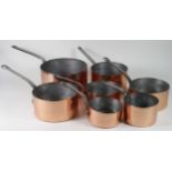 Seven copper saucepans of various sizes, including three stamped Harrods, largest diameter 26cm