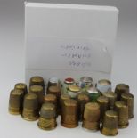 Thimbles. A collection of twenty-four mostly brass thimbles (several with inscribed friezes),