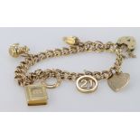 9ct / Yellow metal charm bracelet with a small quantity of charms attached. Total weight 20.2g