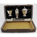 Three piece silver cruet set, mustard, pepper & salt, blue glass liner, set is boxed. Hallmarked A.