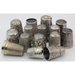 Fifteen white metal thimbles, many with ornate decoration, including a black yet example