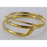 Yellow metal (tests as 20ct) bangle in the form of a snake, with a small diamond on top and rubies