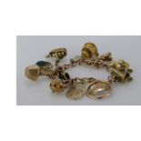 9ct / yellow metal charm bracelet with a good selection of charms attached, total weight 47.5g