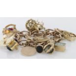 Heavy 9ct charm bracelet with large quantity variety of charms attached, total weight 102.4g