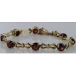 9ct yellow gold bracelet set with eight garnets, box clasp with safety chain and safety catch,