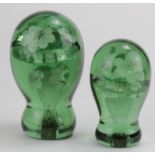 Two moulded green glass paperweights, inset with flower decoration, height 16cm & 13cm approx.