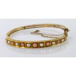 9ct yellow gold hinged bangle with box clasp and safety chain set with coral and pearls, weight 15.
