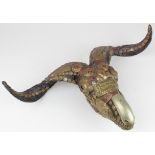 Skull. An unusual ram / sheep skull ornately decorated with brass, enamel etc., possibly used for