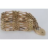 9ct gold seven bar gate bracelet with safety chain, approx 24.9g