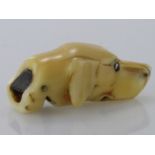 Ivory whistle depicting a dogs head, with inset glass eyes circa late 19th to early 20th Century