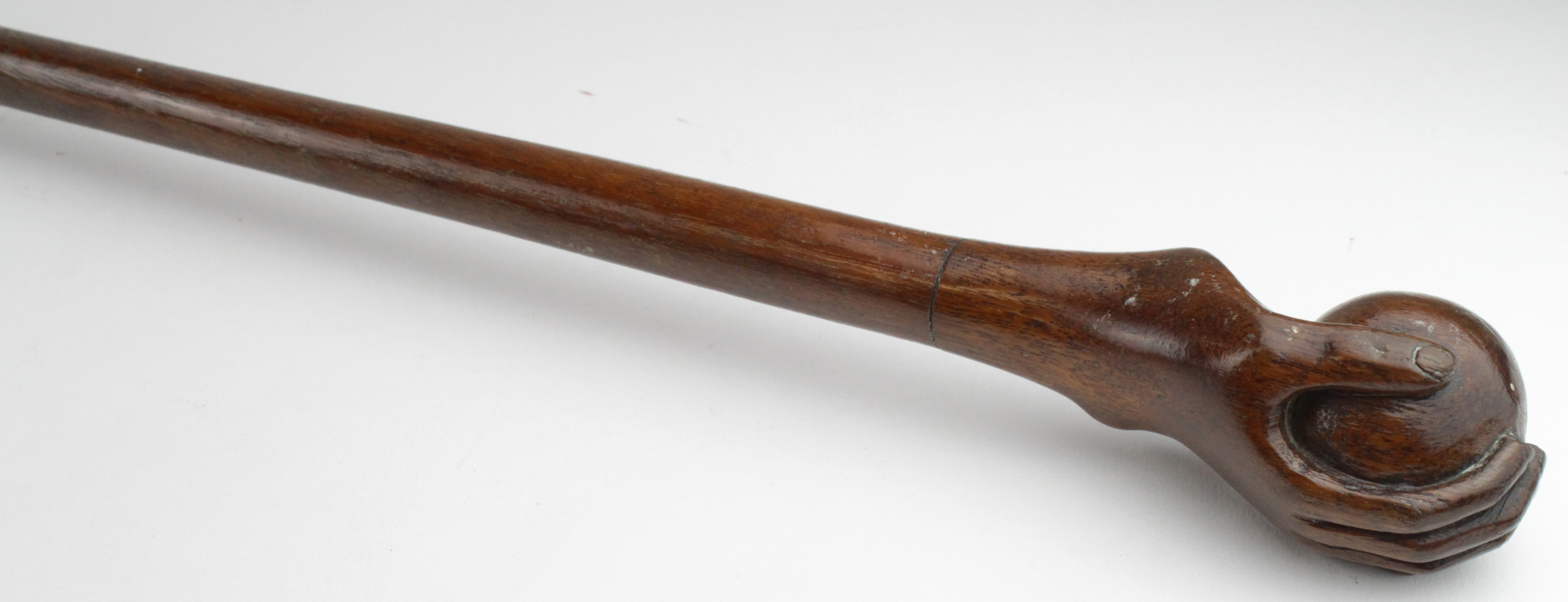 Walking Cane. A walking cane with carved knop depicting a hand & ball, on fruitwood shaft, length