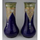 Royal Doulton. A pair of Royal Doulton blue glazed stoneware vases, with floral decoration,