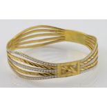 High carat (tests as approx 22ct) two colour wave design slave bangle, weight 33.6g