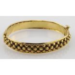 High carat (tests as approx 22ct) hinged yellow gold bangle, weight 26.4g