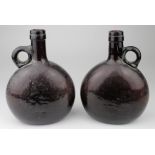 Glass bottles. A pair of 18th Century glass bottles (possibly for spirits or wine) each with small