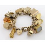 9ct charm bracelet with a good variety of charms attached, total weight 64.3g