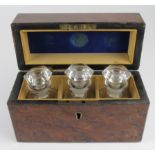 Three glass perfume / pharmaceutical bottles, each with glass stoppers, contained in a fitted walnut