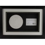 Plaster cast of the London 2012 Olympic Games prize medal, mounted in a frame with a card signed