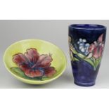 Moorcroft. Two Moorcroft pieces, comprising a blue beaker vase & a green bowl, both with floral