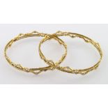 Set of two high carat (tests as approx 22ct) yellow and white gold slave bangles, weight 30.9g