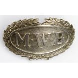 Cap badge 'M.W.B.', surrounded by wreath, in white metal