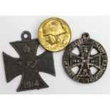 German military related items comprising a brass badge with soldiers head & 2 base metal medals