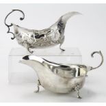 Two silver sauceboats, one plain; hallmarked Chester, 1913 & one decorated with various scenes which