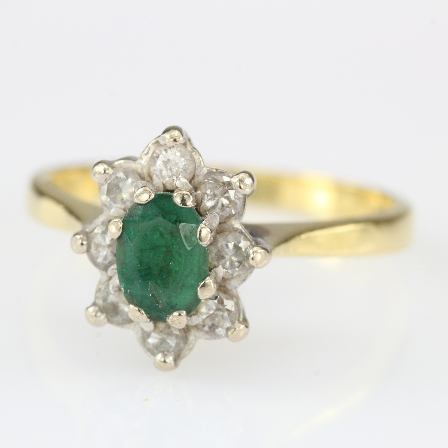 18ct yellow gold emerald and diamond oval cluster ring, total diamond weight approx. 0.25ct.