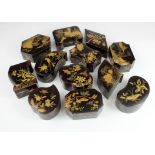 Twelve Japanese black lacquered boxes of various shapes, each with gilt decoration to lids,